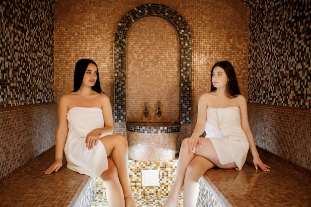 Conceito de estilo de vida saudável de spa de beleza Lindas garotas relaxando no spa turco de luxo com sauna hammam