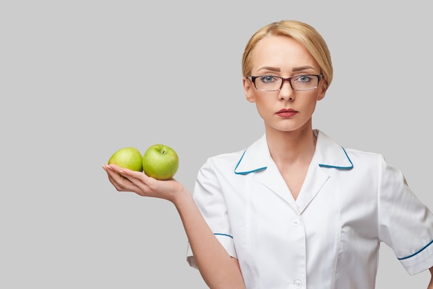 Foto conceito de estilo de vida saudável do médico nutricionista - segurando maçã verde fresca orgânica.