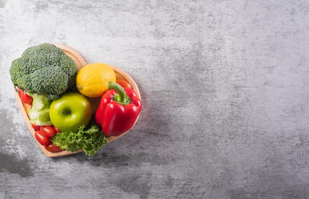 Conceito de estilo de vida saudável, legumes frescos ou nutrição alimentar saudável em placa de coração em fundo de pedra.