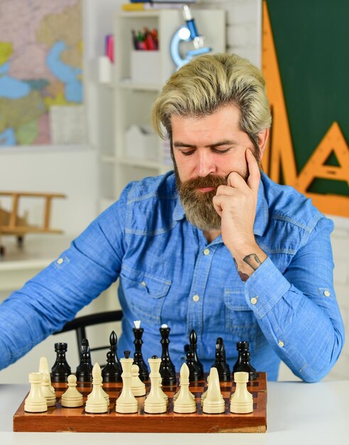 Pensando na próxima etapa. o xadrez é um ginásio da mente. aula de xadrez.  conceito de estratégia. professor da escola. jogo de tabuleiro. figuras no  tabuleiro de xadrez de madeira. homem inteligente hippie jogando xadrez.  passatempo intelectual
