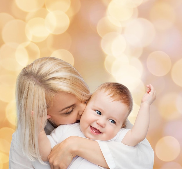 conceito de família, criança e paternidade - mãe feliz beijando bebê sorridente