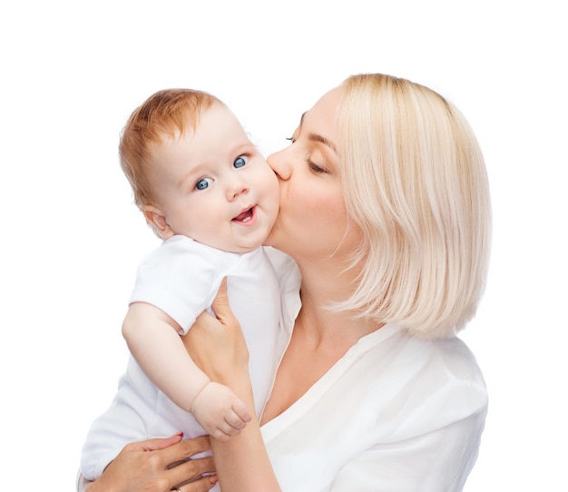 Conceito de família, criança e paternidade - mãe feliz beijando um bebê sorridente