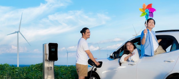 Conceito de família feliz progressiva na turbina eólica com veículo elétrico