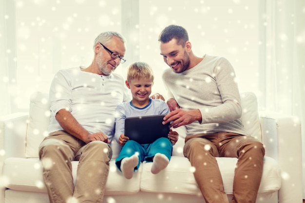 conceito de família, geração, tecnologia e pessoas - sorrindo pai, filho e avô sentado no sofá com computador tablet pc em casa