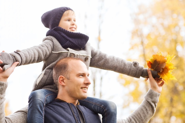 conceito de família, infância, temporada e pessoas - feliz pai e filho se divertindo no parque outono