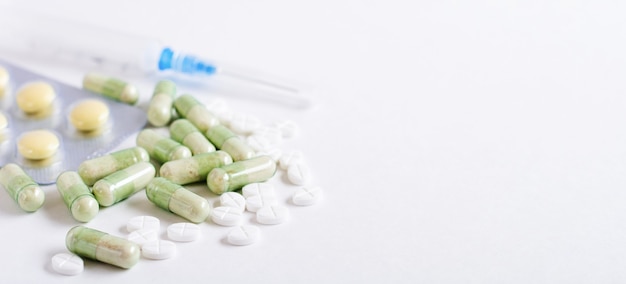 Conceito de farmácia médica de comprimidos brancos e cápsulas verdes