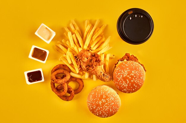 Conceito de fast food com restaurante frito gorduroso, como anéis de cebola, hambúrguer, frango frito e fren