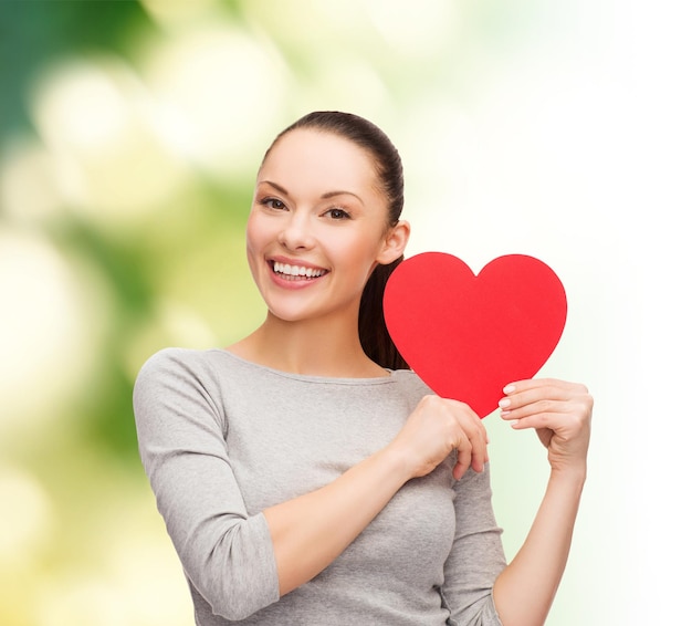 Conceito de felicidade, amor e saúde - mulher asiática sorridente com coração vermelho