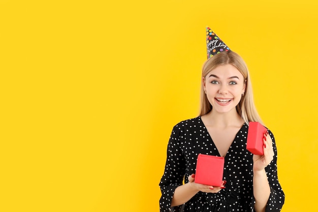 Conceito de feliz aniversário com garota atraente em fundo amarelo