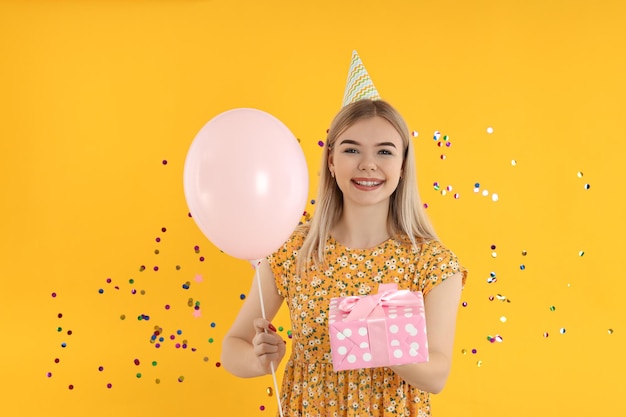 Conceito de feliz aniversário jovem em fundo amarelo