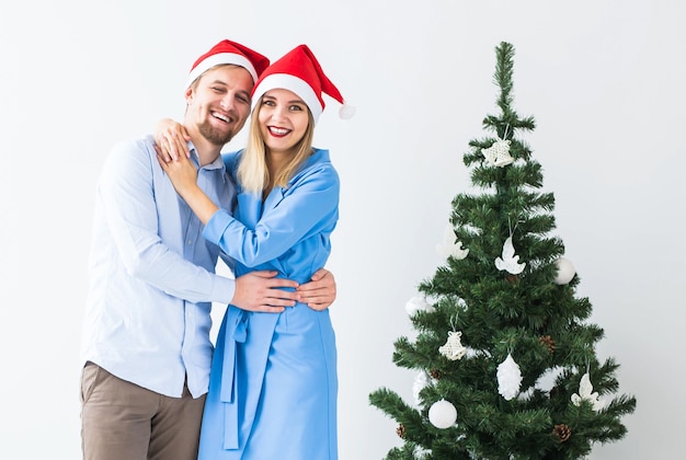 Conceito de feriados e celebração - jovem casal comemorando o Natal em casa