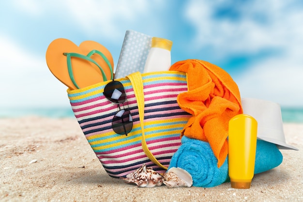 Conceito de férias, bolsa colorida com artigos de praia na praia de verão