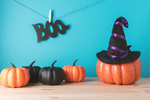 Conceito de férias com decoração de abóbora de Halloween e chapéu de bruxa na mesa de madeira