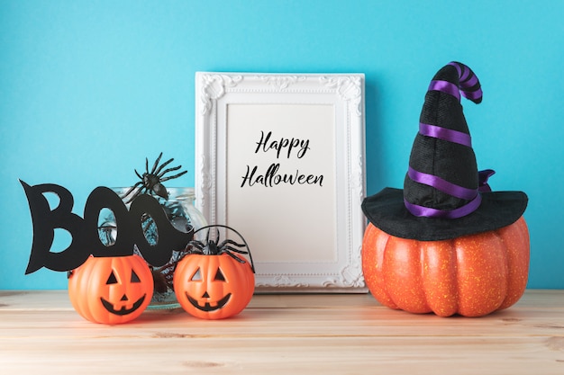 Conceito de férias com decoração de abóbora de Halloween e molduras para fotos na mesa de madeira