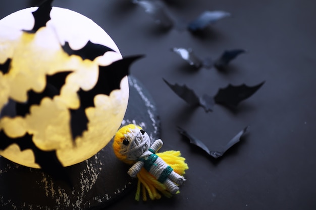 Conceito de férias de halloween. mesa de pedra velha em forma de morcegos. decorações de papel de halloween em fundo escuro. brinquedo da lua.