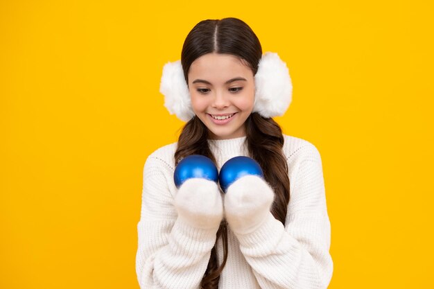 Foto conceito de férias de inverno adolescente alegre no suéter de natal desejando feliz natal em pé contra um fundo amarelo rosto feliz emoções positivas e sorridentes de adolescente