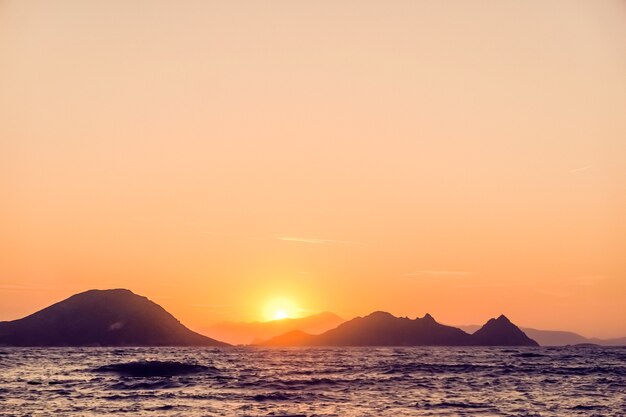 Conceito de férias de praia vintage e crepúsculo da natureza, pôr do sol de verão na costa do mar mediterrâneo e vista para a montanha