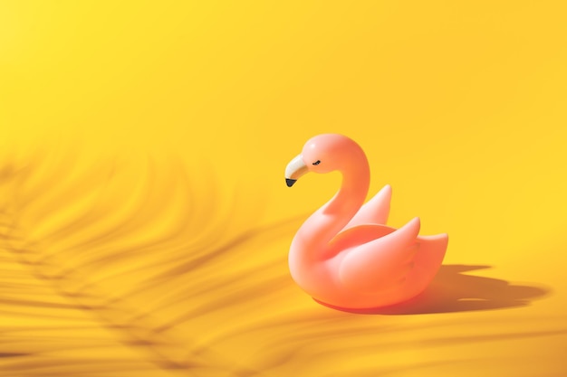 Conceito de férias de verão com flamingo de brinquedo no espaço de cópia pastel criativa de fundo amarelo