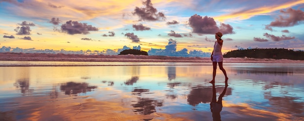 Conceito de férias de viagens de verão. Mulher asiática com chapéu relaxando e passeando na praia de Kata ao pôr do sol em Phuket, Tailândia