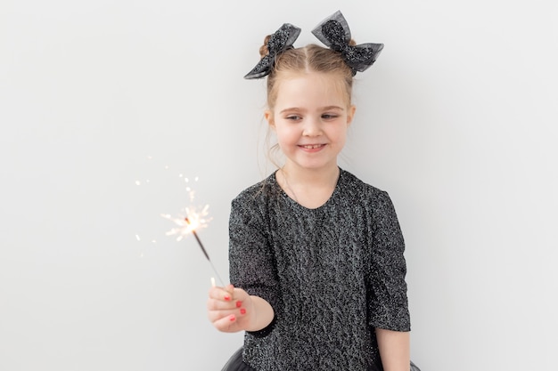 Conceito de férias, Natal e ano novo - criança feliz segura diamante aceso na mão sobre fundo branco com espaço de cópia.