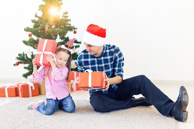 Conceito de férias, natal, família e felicidade - close-up de pai e filha com caixa de presente