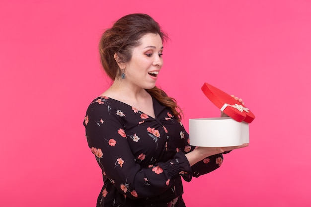 Conceito de férias, presente e surpresa - Beleza menina feliz com caixa de presente de dia dos namorados em rosa