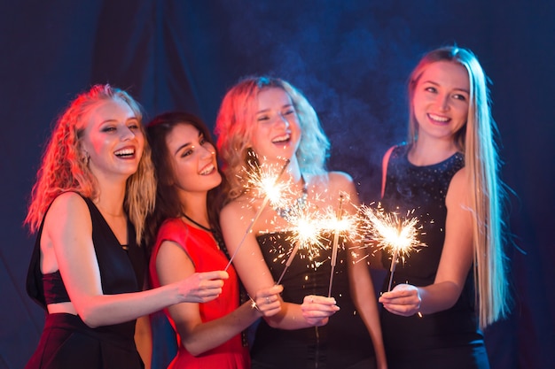 Conceito de festa, ano novo e feriados de aniversário - grupo de amigas comemorando segurando estrelinhas.