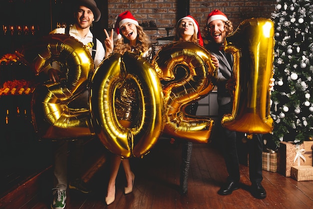Conceito de festas, pessoas e feriados de ano novo - mulheres e homens comemorando a passagem de ano de 2021.