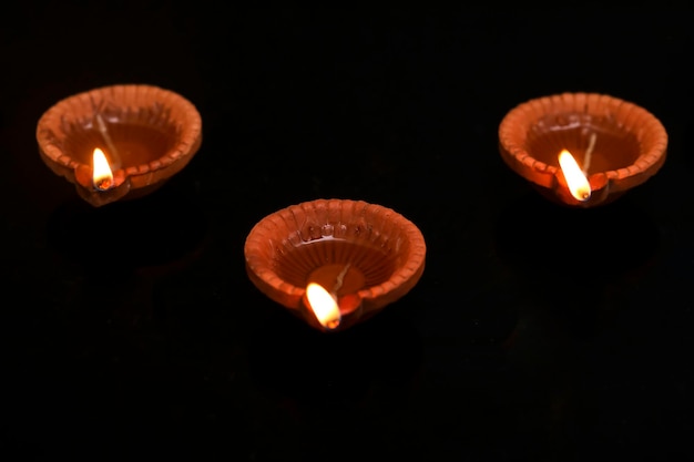 Conceito de festival indiano diwali lâmpadas de óleo tradicionais em fundo escuro