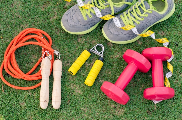 Foto conceito de fitness com equipamento de exercício no fundo da grama verde