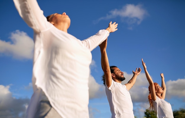 conceito de fitness, desporto, ioga e estilo de vida saudável - grupo de pessoas a meditar ao ar livre