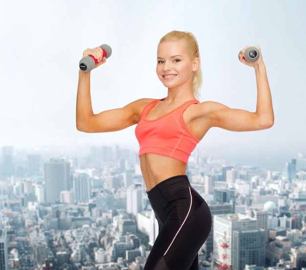 conceito de fitness, esporte e dieta - sorrindo linda mulher desportiva com halteres