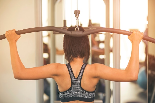 Conceito de fitness, esporte, treinamento, ginásio e estilo de vida - grupo de mulheres excercising com barras no ginásio