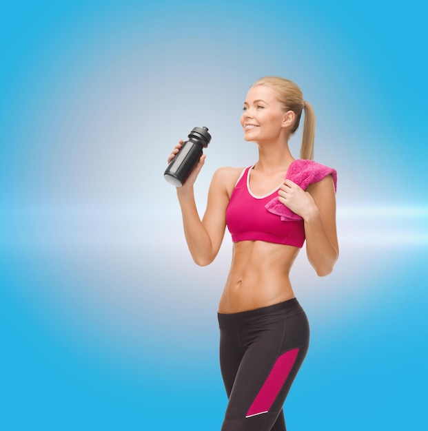 conceito de fitness, saúde e dieta - mulher desportiva sorridente bebendo água da garrafa de esportista