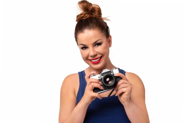 Conceito de fotógrafo amador mulher bonita e atraente segurando uma câmera SLR retrô e sorrindo isolada em um fundo branco