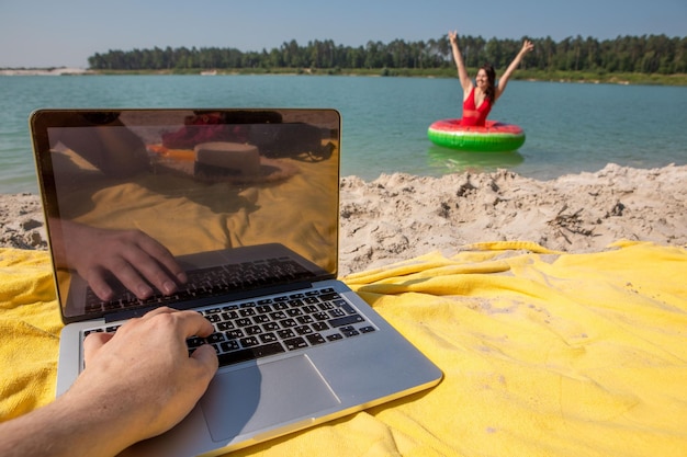 Conceito de freelancer trabalhando em laptop no espaço de cópia de praia arenosa