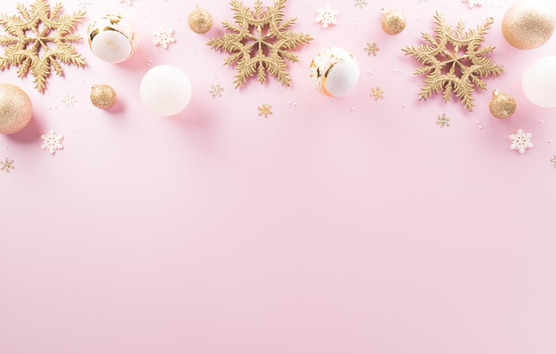 Foto conceito de fundo de natal e ano novo vista superior da estrela de bola de natal e floco de neve em fundo rosa pastel