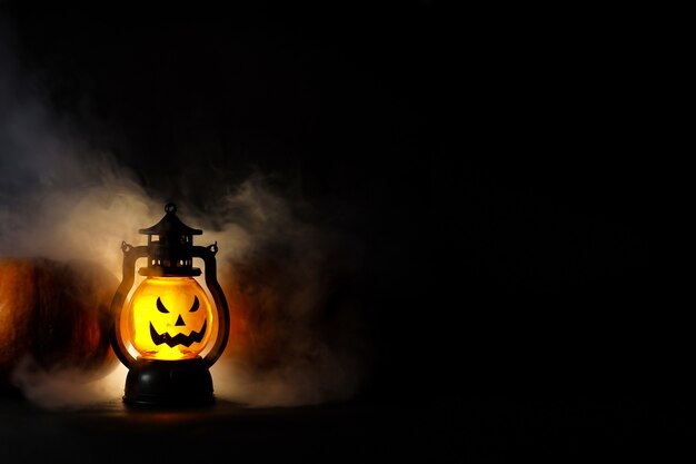 Conceito de fundo escuro de Halloween com lanterna brilhante e fumaça