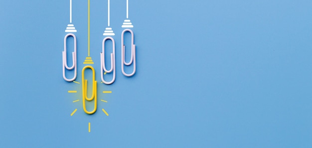 Foto conceito de grandes idéias com clipe de papel pensando criatividade lâmpada sobre fundo azul