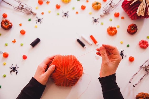 Foto conceito de halloween diy. costurando uma abóbora e um fantasma.