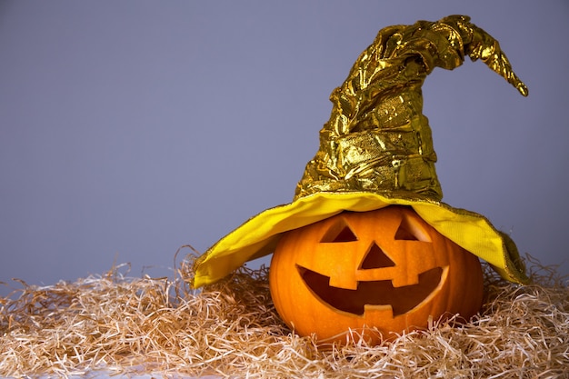 Conceito de Halloween - grande abóbora Jack-O-Lantern com chapéu de bruxa sobre fundo cinza