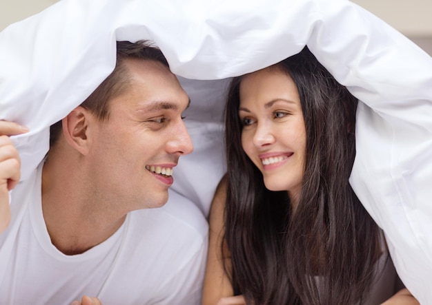 conceito de hotel, viagens, relacionamentos e felicidade - casal feliz na cama
