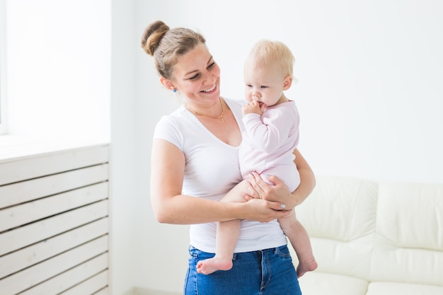 Conceito de infância, família e maternidade - mãe segurando uma doce menina