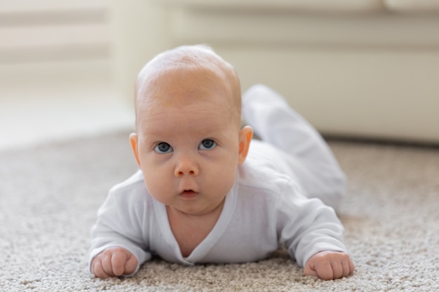 Foto conceito de infância, infância e pessoas - menina aprendendo a engatinhar no chão