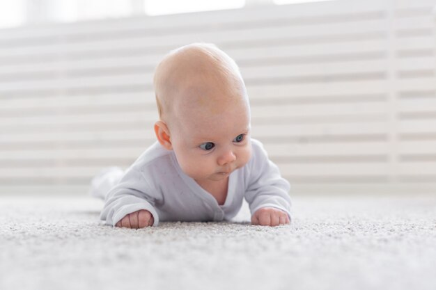 Conceito de infância, infância e pessoas - menino ou menina rastejando no chão em casa.