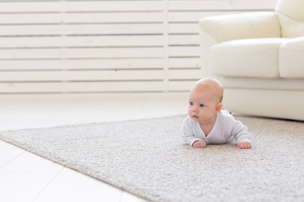 Conceito de infância, infância e pessoas - pequeno bebê deitado no chão