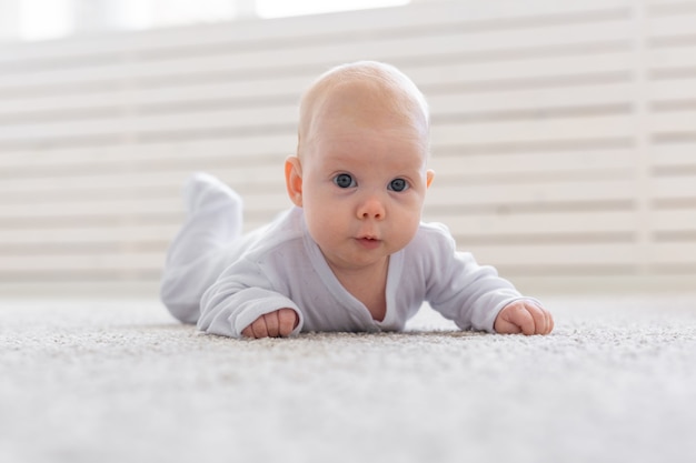 Conceito de infância, infância e pessoas - pequeno bebê deitado no chão