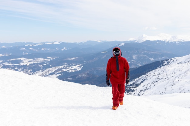 Conceito de inverno, lazer, esporte e pessoas - Snowboarder fica na encosta do sertão e segura o snowboard. Conceito de esqui