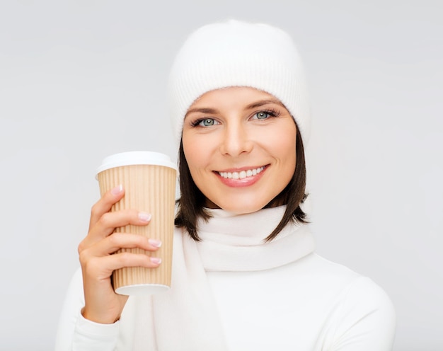 conceito de inverno, pessoas, felicidade, bebida e fast food - mulher com chapéu e xícara de chá ou café para viagem