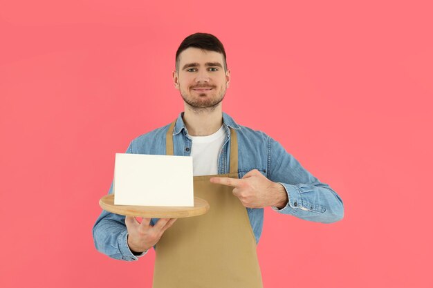 Conceito de jovem garçom de ocupação em fundo rosa